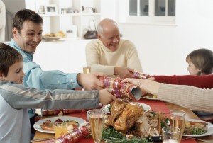 Family Pulling Party Favors During Christmas Dinner Tips for the holidays - shown by family having happy dinner