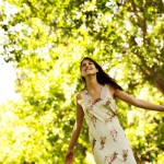 Young Woman Standing with Arms Stretched Out meditation for relaxation shown by happy woman standing with arms stretched out